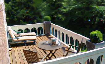 a wooden deck with a table and chairs , surrounded by trees and greenery , creating a serene outdoor setting at New-Castle