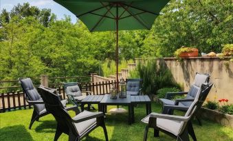 a group of people is gathered around a dining table in a grassy backyard , enjoying a meal and conversation at CasAda