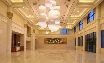 a grand , well - lit lobby with large chandeliers hanging from the ceiling and a painting on the wall at Sun Valley Hotel