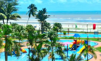 a colorful playground with slides and swings is situated near the beach , overlooking the ocean at De Rhu Beach Resort