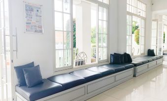 a long bench with blue cushions is positioned in front of a window that has large windows at Victoria Bed & Breakfast