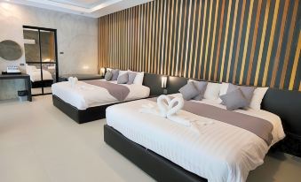 a hotel room with two beds , one on the left and one on the right , both covered in white linens at Baan Chao Mai Beach House