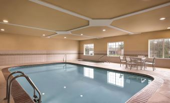 an indoor swimming pool with a large , empty space and a bench at the end at Country Inn & Suites by Radisson, Rocky Mount, NC