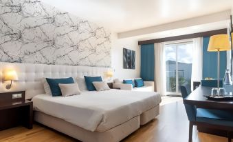 a modern hotel room with white walls , wooden floors , and large windows offering views of the city at Hotel Vale Do Navio