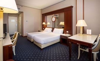 a hotel room with two beds , one on the left and one on the right side of the room at Best Western CTC Hotel Verona