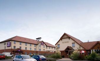 a hotel with a large parking lot and several cars parked in front of it at Premier Inn Grantham