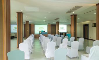 a conference room set up for a meeting , with chairs arranged in rows and a projector on the wall at Gassan Khuntan Golf & Resort