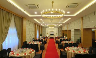 a banquet hall with tables and chairs set up for a formal event , surrounded by red carpet and chandeliers at StarLodge