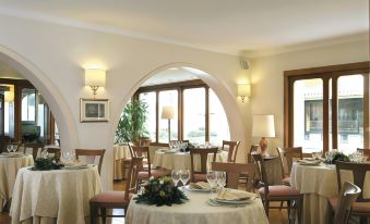 a well - lit dining room with several tables and chairs arranged for a group of people to enjoy a meal together at American Hotel