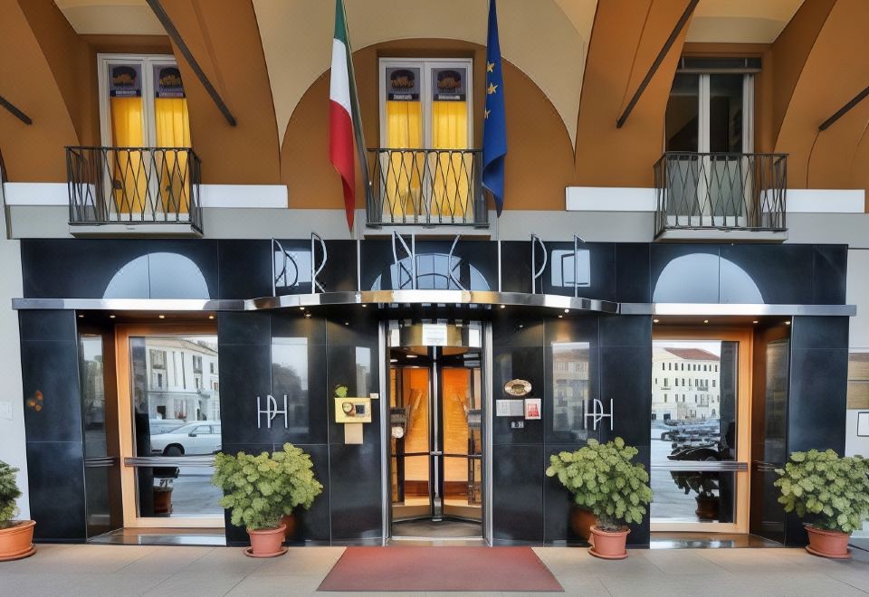 "a black and white building with the word "" rinky "" on it , along with two flags hanging from the entrance" at Phi Hotel Principe