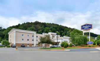 a large , modern hotel building with a blue and white logo is situated on a street corner at Wingate by Wyndham Steubenville