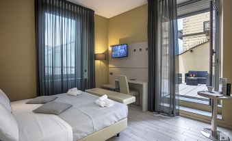 a modern hotel room with a large bed , two chairs , and a flat - screen tv on the wall at Hotel Diplomatic