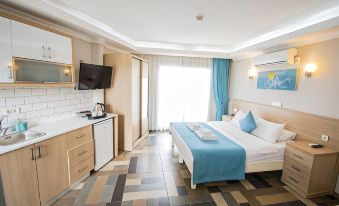 a hotel room with a blue bed , white cabinets , and a window , along with other furniture and appliances at M Suite