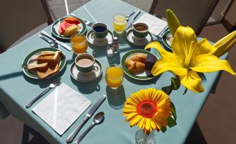 a dining table set with a variety of breakfast items , including plates , cups , and utensils at Hotel Diplomat