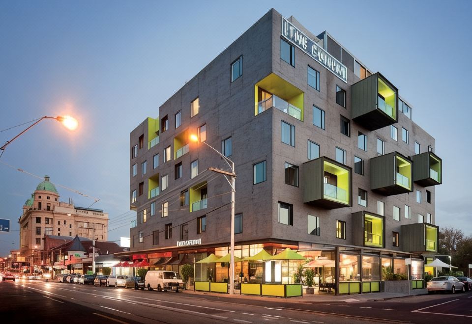 "a modern building with a yellow facade and the word "" the terrace "" on it is lit up at night" at The Cullen Melbourne - Art Series