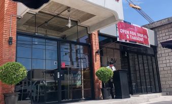 "a brick building with a red sign that says "" yen tea "" and a person standing outside" at The Bricks Hotel