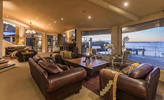 a spacious living room with multiple couches and chairs arranged around a coffee table , creating a comfortable atmosphere for relaxation and entertainment at Delamore Lodge