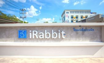 a large sign for the brand irabbit is displayed on a concrete platform in front of a building at IRabbit Hotel