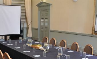 a conference room with a table set for a meeting , complete with glasses , pens , and water bottles at The Rutland Arms Hotel, Bakewell, Derbyshire