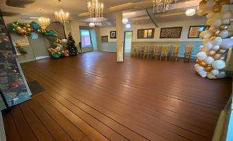 a large room with wooden floors and a long table is decorated for a party at The Peppermill Town House Hotel & Restaurant