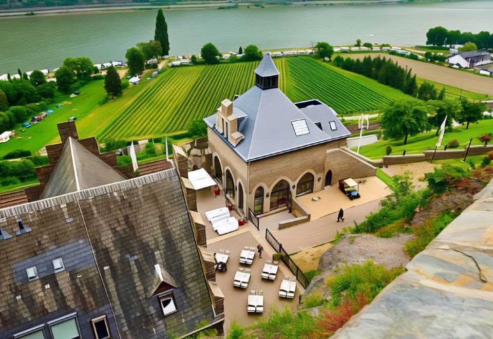 a rooftop bar overlooking a body of water , with several chairs and tables set up for patrons to enjoy the view at Burg Reichenstein