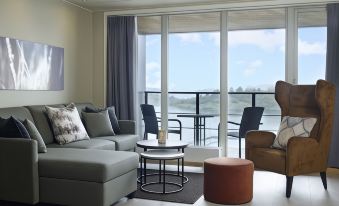 a living room with a couch , chairs , and a chair in front of a window overlooking the ocean at Son Spa, an Ascend Member
