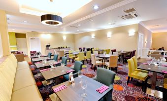 a dining room with multiple tables and chairs arranged for a group of people to enjoy a meal together at Link Hotel