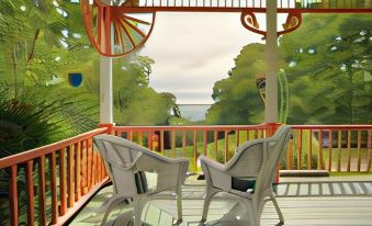 a wooden deck with two white rocking chairs and a view of the ocean through an open window at Victorian by the Sea