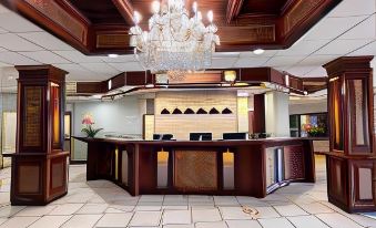 a hotel lobby with a large reception desk and a crystal chandelier hanging from the ceiling at Silver Beach Hotel