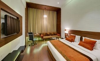 a large bed with orange blankets is in a room with wooden walls and floors at Hotel Centre Point