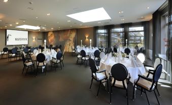 a large dining room with tables and chairs set up for a formal event , possibly a wedding reception at Van der Valk Volendam