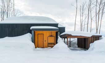 two wooden cabins , one on the left side and the other on the right side of a snow - covered landscape at Birchwood Chalet