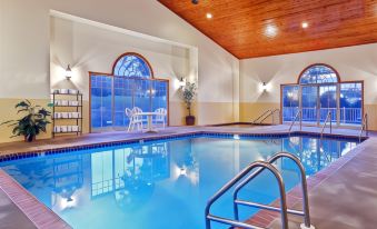 an indoor swimming pool surrounded by windows , allowing natural light to fill the space at Country Inn & Suites by Radisson, Ft. Atkinson, WI