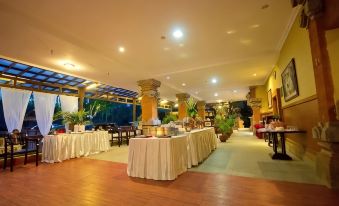 a long dining table filled with a variety of food items and utensils , ready for a party or event at Ubud Hotel & Cottages