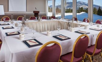 a conference room set up for a meeting , with tables and chairs arranged in rows at White Mountain Hotel and Resort