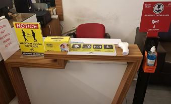 a wooden desk with various items , including a yellow card and a box of stickers , placed on it at Royal Ascot