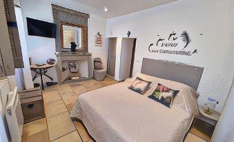 a clean and well - organized bedroom with a king - sized bed , a tv , and various pieces of furniture at La Bastide