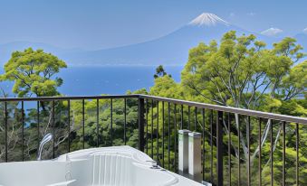 There is a balcony with an ocean view and a hot tub on top located next to another set at Nishi-izu Resort Kumo To Kaze To／Tenkuu-Terrace