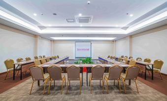 a conference room with a long table and chairs arranged in a semicircle , providing seating for a large group of people at favehotel Bitung