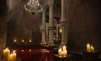 a luxurious room with multiple candles , pillars , and a chandelier , creating a warm and inviting atmosphere at Sacred House
