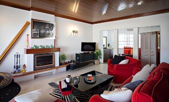 a spacious living room with red couches , a fireplace , and a flat - screen tv mounted on the wall at Hotel Monaco