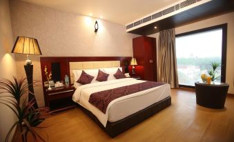 a large bed with a white and red patterned blanket is in a room with wooden floors at Hotel La