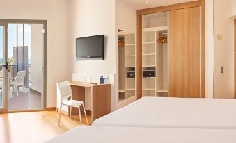 a modern bedroom with a bed , desk , and chair , as well as a closet and a flat - screen tv at RH Bayren Hotel & Spa