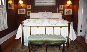a bedroom with a white bed , gold metal headboard , and matching pillows , along with a green footboard at The White House Inn