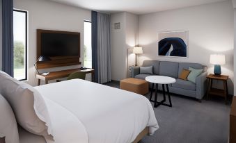 a modern hotel room with a bed , couch , and tv , along with other furniture and amenities at Staybridge Suites Pittsburgh Airport