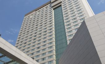 In front of a large building with numerous windows on its side, there is an office block at Parsian Azadi Hotel