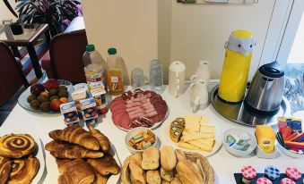 a dining table with a variety of food items , including sandwiches , bread , and beverages , arranged in various bowls and cups at Club Wyndham Normandy