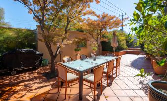 a patio with a table , chairs , and an umbrella is shown in front of trees at Gateway on Monash