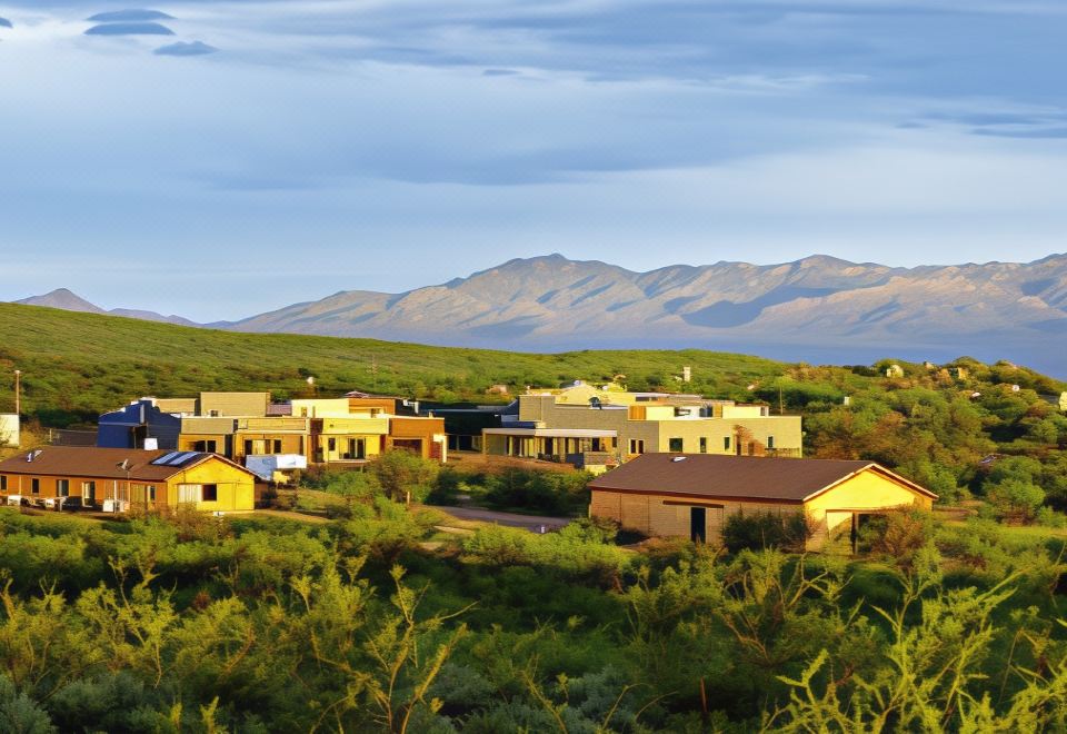 a small town surrounded by mountains , with several houses in the foreground and a mountain range in the background at Tombstone Monument Guest Ranch