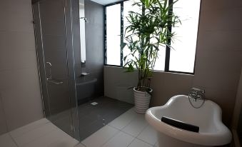 a modern bathroom with a large window , a shower , and a white bathtub , all set against a gray wall at Pinetree Hotel